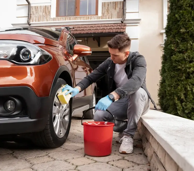 Lavage auto à domicile Asnières-sur-Oise : professionnel intervenant sur un véhicule